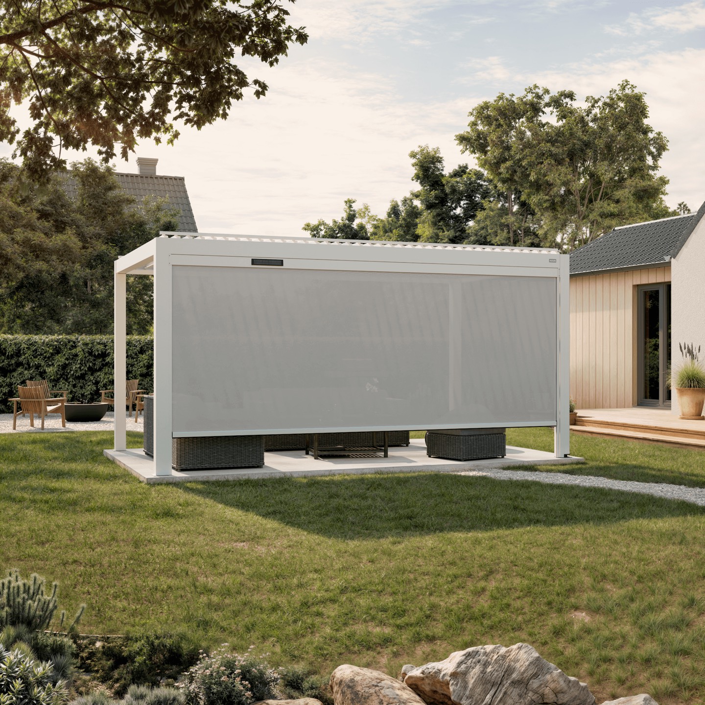 Solar-powered retractable sun shade in light fabric lowered along the full side of a white Ombra pergola
